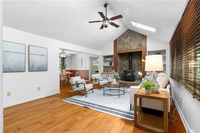 1920 Jett Ridge Rd, Cumming, GA 30041 - living room featuring ceiling fan, a wood stove, built in features, baseboards, and vaulted ceiling