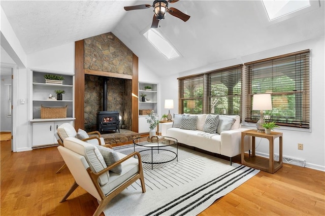 1920 Jett Ridge Rd, Cumming, GA 30041 - living area with a skylight, a wood stove, ceiling fan, wood finished floors, and lofted ceiling