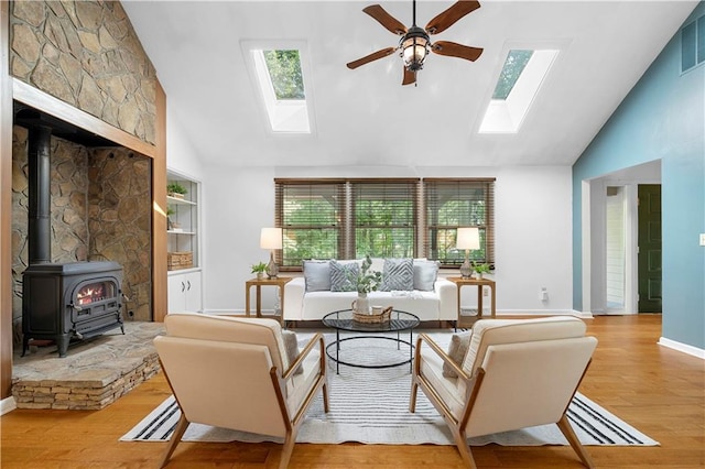 1920 Jett Ridge Rd, Cumming, GA 30041 - living room featuring a skylight, high vaulted ceiling, ceiling fan, a wood stove, and wood finished floors