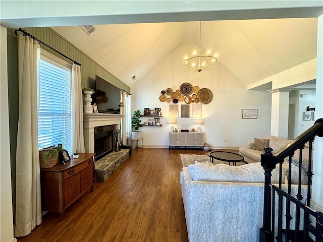 living room with wood finished floors, visible vents, high vaulted ceiling, an inviting chandelier, and a fireplace