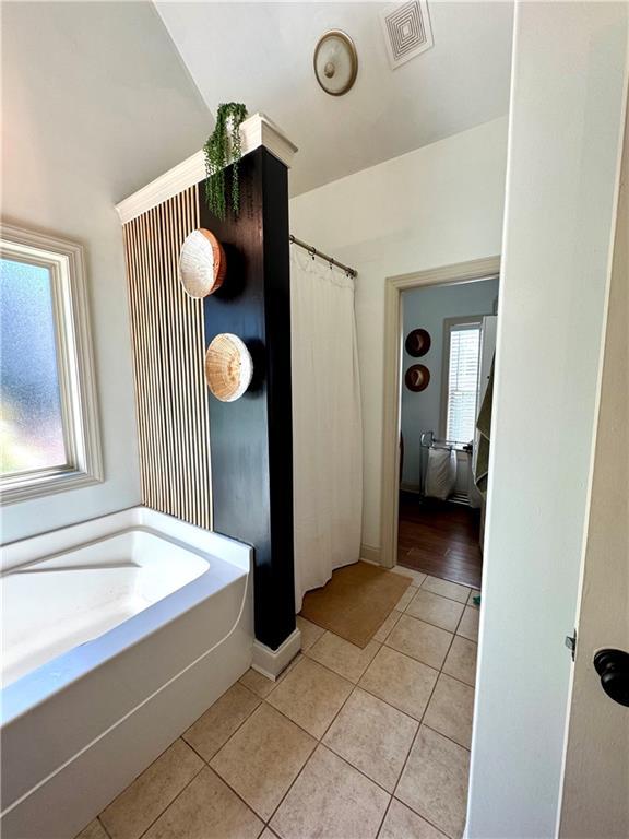 full bath with tile patterned floors, visible vents, a shower with curtain, and a healthy amount of sunlight