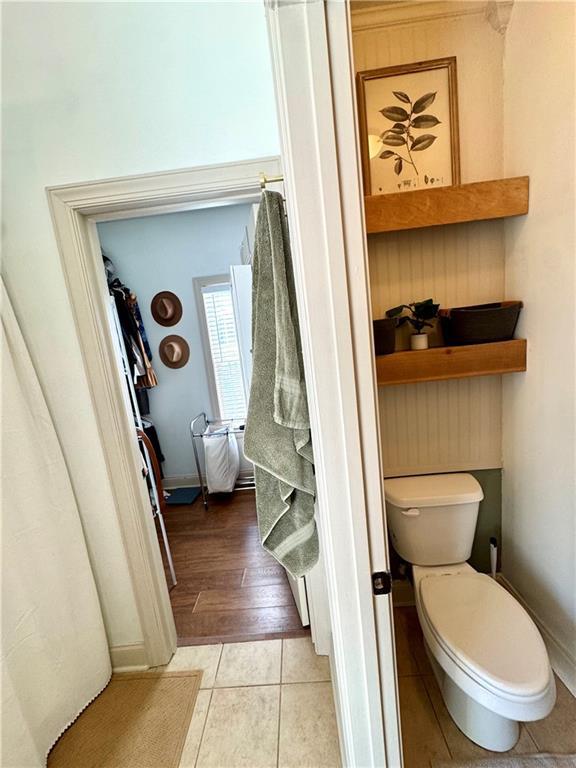 bathroom with tile patterned floors, toilet, and baseboards