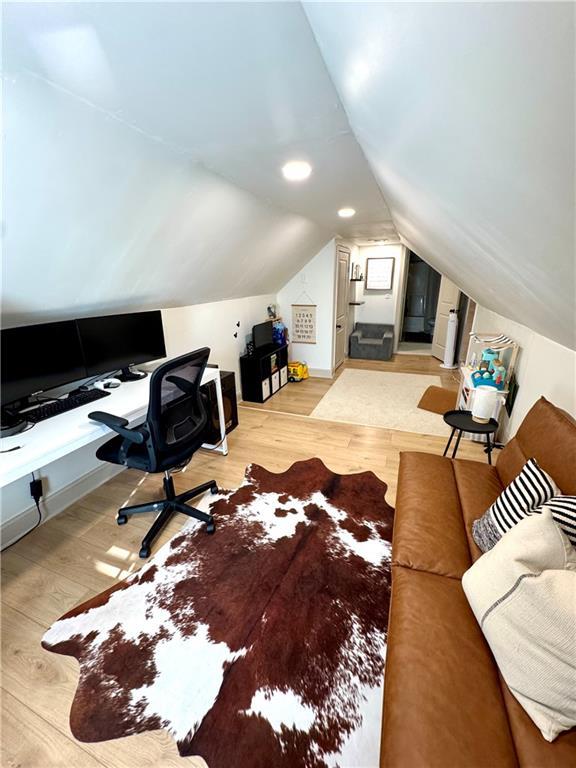 office featuring light wood-type flooring and lofted ceiling