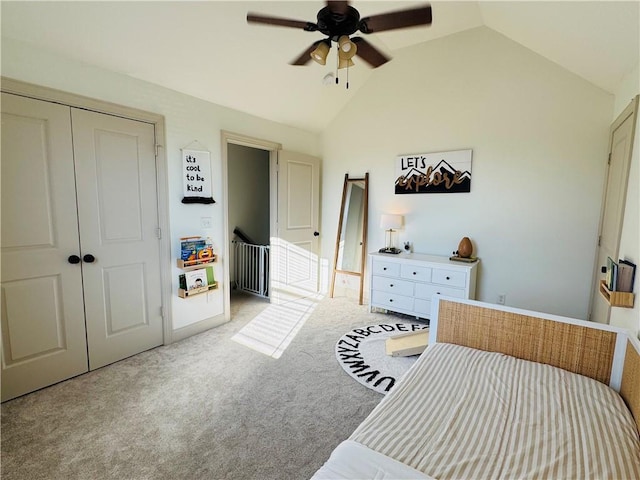 bedroom with a closet, light carpet, lofted ceiling, and a ceiling fan