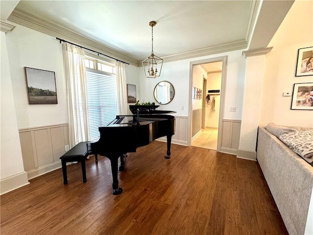 living area with dark wood finished floors, wainscoting, and crown molding