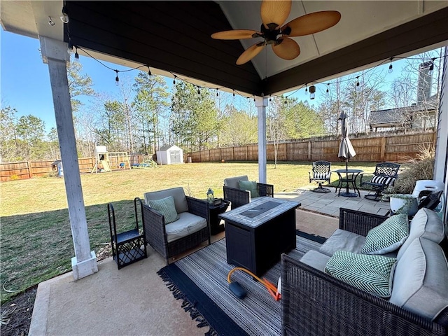 view of patio / terrace with a fenced backyard, an outdoor structure, outdoor lounge area, a storage shed, and a playground