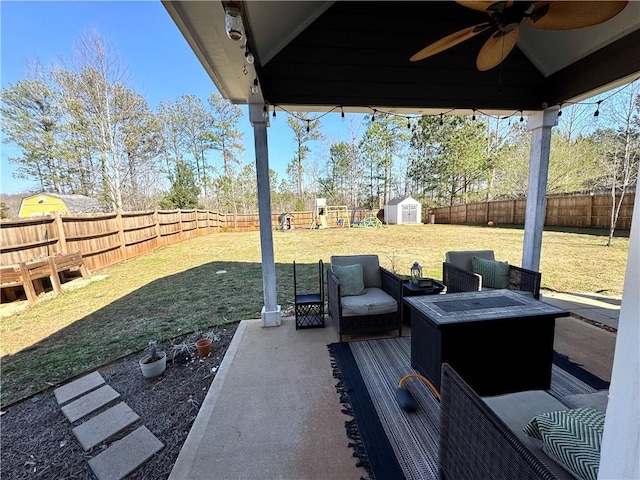 view of patio featuring a ceiling fan, a fenced backyard, a shed, an outdoor structure, and an outdoor hangout area