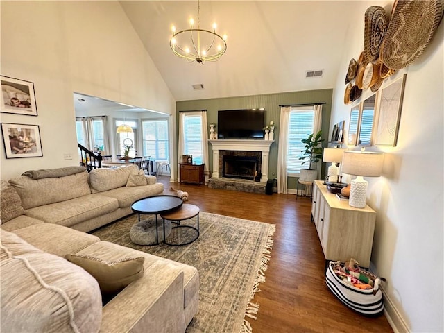 living area featuring dark wood-style floors, visible vents, a wealth of natural light, and a chandelier