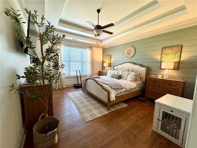 bedroom featuring dark wood-style floors, ceiling fan, and a tray ceiling