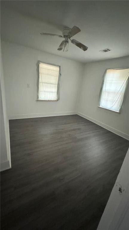 spare room with ceiling fan and dark hardwood / wood-style floors