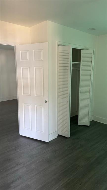 unfurnished bedroom with dark wood-type flooring