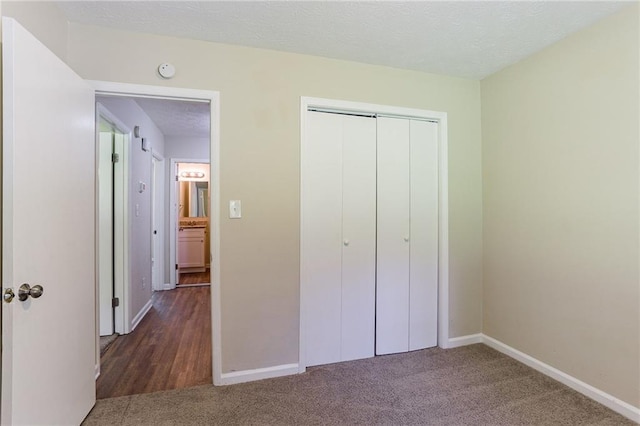 unfurnished bedroom with a closet and dark carpet