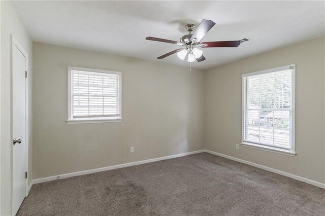 carpeted empty room with ceiling fan and a healthy amount of sunlight