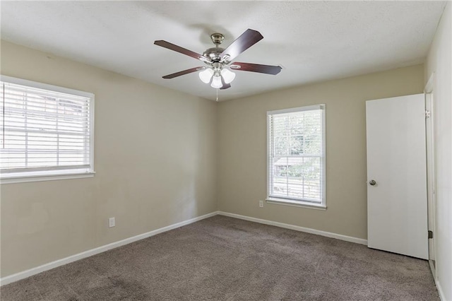 spare room featuring light colored carpet and ceiling fan