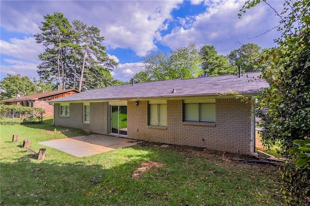 rear view of property featuring a lawn and a patio area