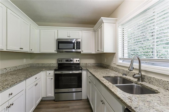 kitchen featuring dark hardwood / wood-style floors, white cabinetry, sink, and stainless steel appliances