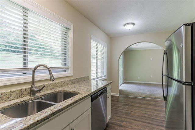 kitchen featuring light stone countertops, appliances with stainless steel finishes, dark hardwood / wood-style floors, and sink