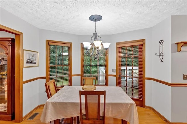 40 Picketts Forge Dr W, Acworth, GA 30101 - dining area with a chandelier, light wood-type flooring, baseboards, and a textured ceiling