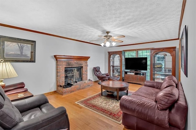 40 Picketts Forge Dr W, Acworth, GA 30101 - living room with wood finished floors, a fireplace, ceiling fan, crown molding, and a textured ceiling
