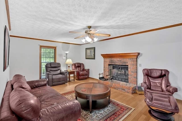 40 Picketts Forge Dr W, Acworth, GA 30101 - living room featuring wood finished floors, ceiling fan, a brick fireplace, a textured ceiling, and ornamental molding