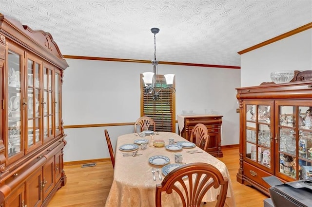 40 Picketts Forge Dr W, Acworth, GA 30101 - dining area featuring a chandelier, light wood-style flooring, ornamental molding, baseboards, and a textured ceiling