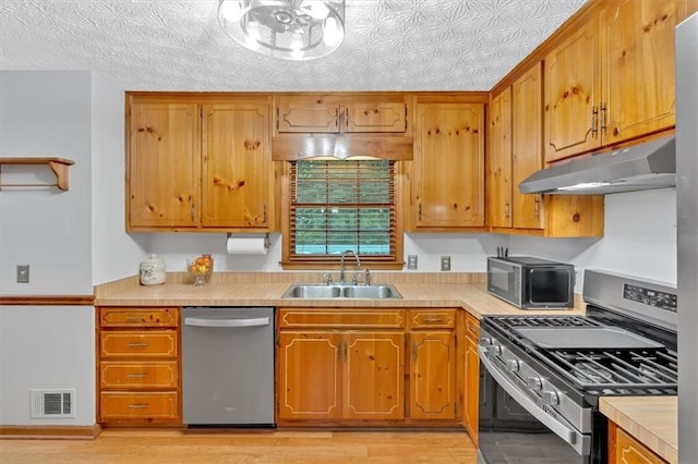 40 Picketts Forge Dr W, Acworth, GA 30101 - kitchen with stainless steel appliances, under cabinet range hood, a sink, and light wood-style floors