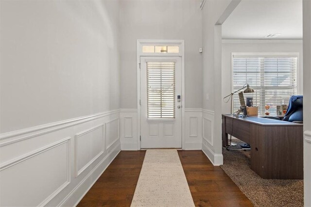 entryway with dark wood-type flooring, a healthy amount of sunlight, and ornamental molding