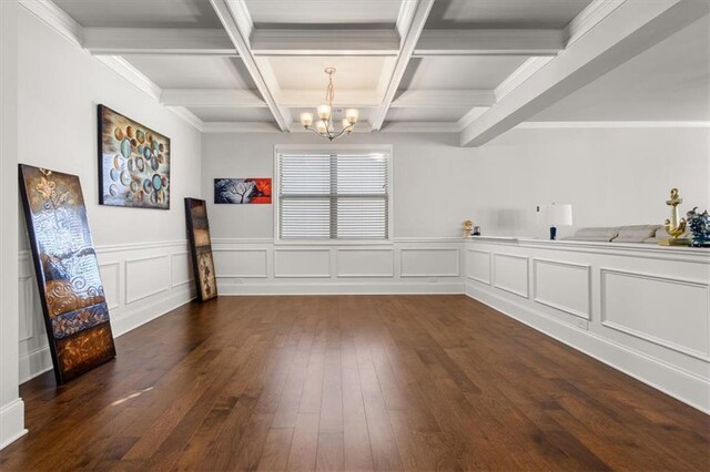 unfurnished dining area with ornamental molding, coffered ceiling, dark wood-type flooring, beam ceiling, and a chandelier