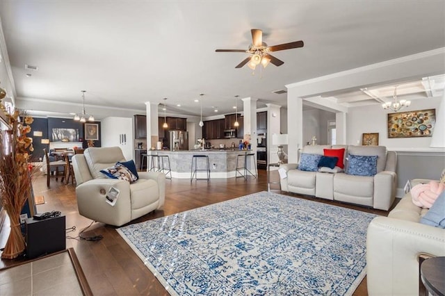 living room featuring ceiling fan with notable chandelier, ornamental molding, and dark wood-type flooring