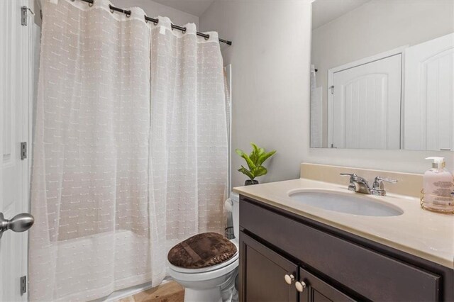 bathroom with a shower with curtain, vanity, and toilet