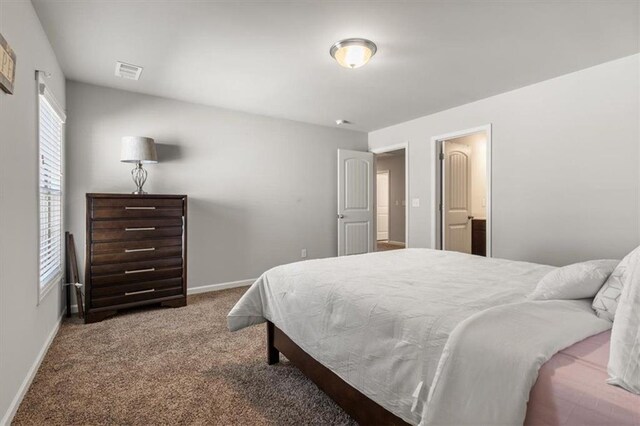 carpeted bedroom with ensuite bath