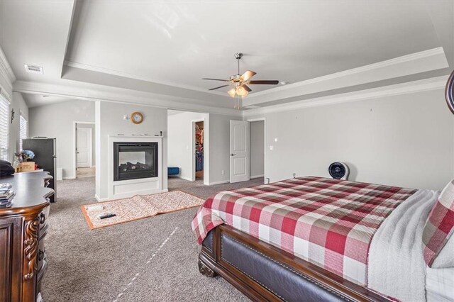 bedroom with a tray ceiling, ceiling fan, carpet flooring, and ornamental molding