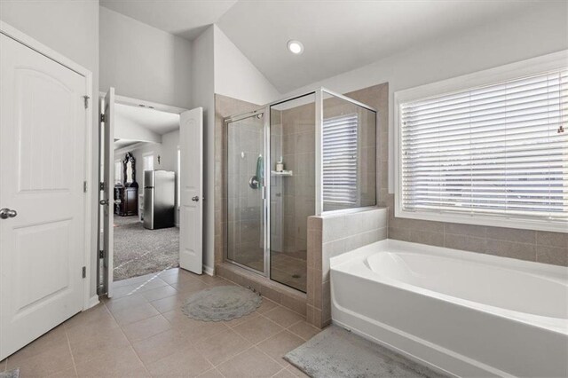 bathroom featuring tile patterned floors, vaulted ceiling, and shower with separate bathtub