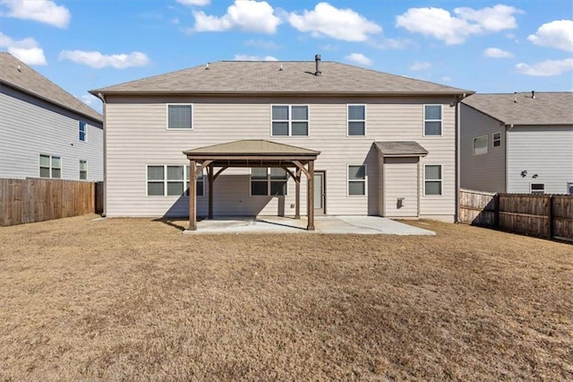 rear view of property with a gazebo, a patio area, and a lawn