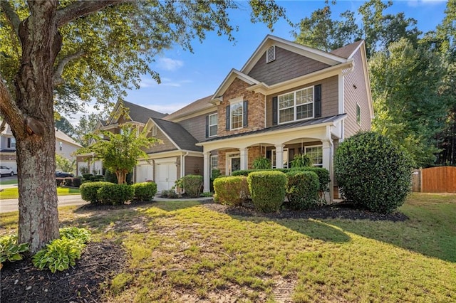 view of front of property with a front yard, fence, and an attached garage