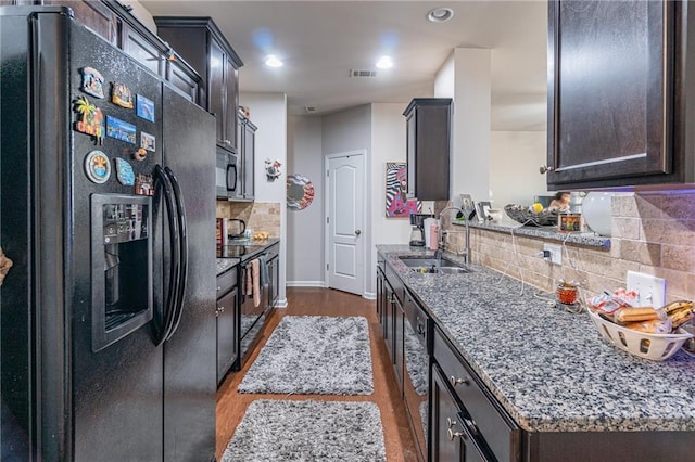 kitchen featuring dark wood-type flooring, sink, tasteful backsplash, dark brown cabinetry, and stainless steel appliances