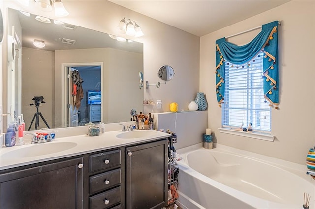 bathroom featuring a washtub and vanity