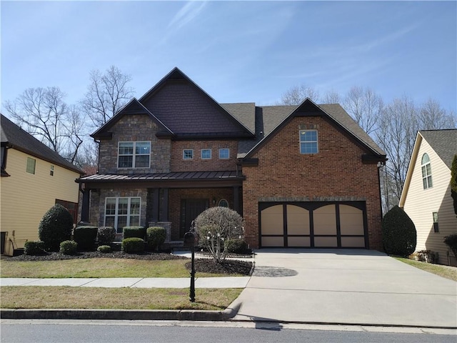 craftsman-style home with a garage, concrete driveway, metal roof, a standing seam roof, and brick siding