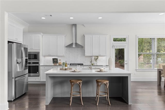 kitchen featuring stainless steel appliances, wall chimney exhaust hood, light countertops, and decorative backsplash