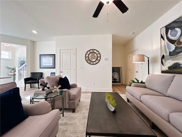 living room with ceiling fan and light hardwood / wood-style flooring