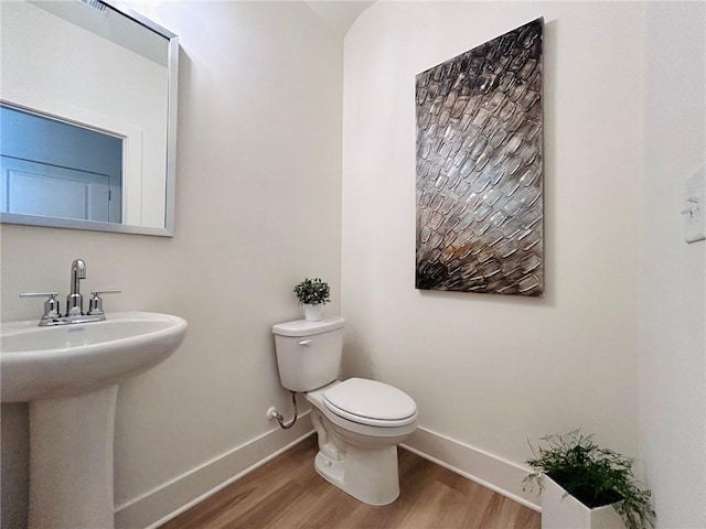 bathroom featuring hardwood / wood-style flooring, toilet, and sink