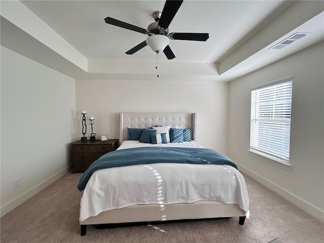 bedroom with carpet, a raised ceiling, and ceiling fan