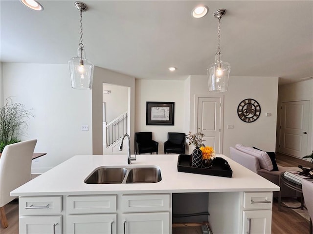 kitchen with white cabinetry, sink, pendant lighting, and a center island with sink