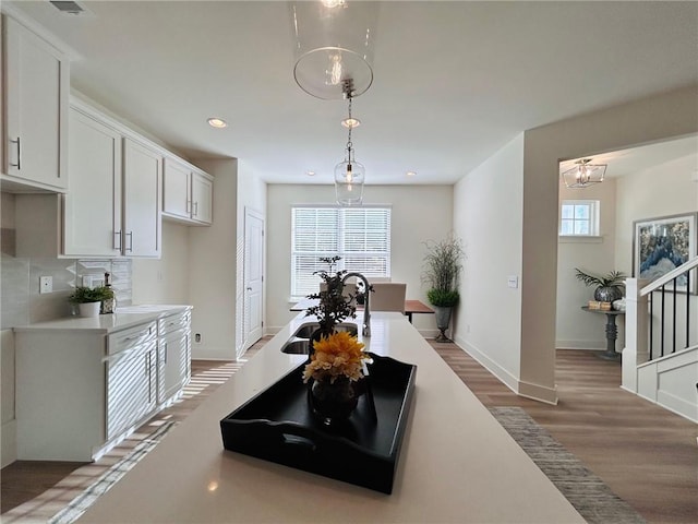 kitchen featuring white cabinets, a notable chandelier, dark hardwood / wood-style floors, and decorative light fixtures