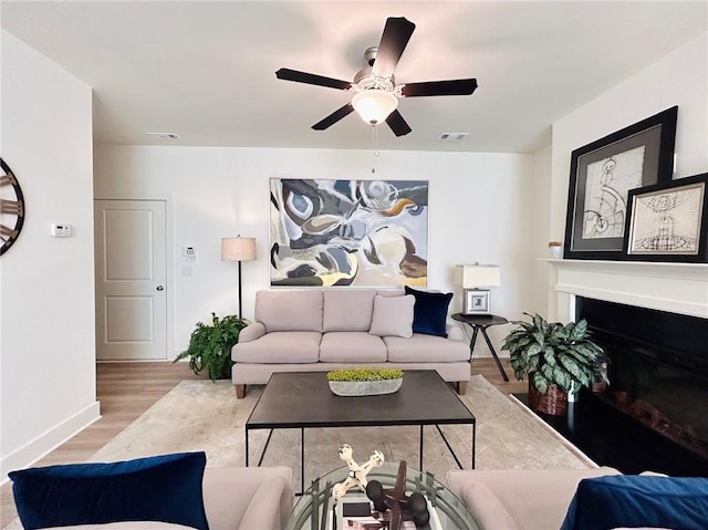 living room featuring ceiling fan and light hardwood / wood-style flooring