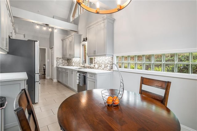 kitchen with a wealth of natural light, stainless steel appliances, light countertops, and tasteful backsplash