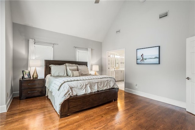 bedroom with visible vents, baseboards, high vaulted ceiling, and wood finished floors