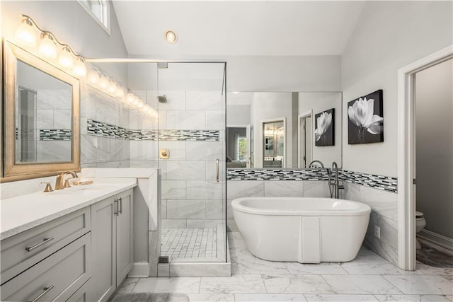 bathroom featuring a shower stall, vanity, marble finish floor, and lofted ceiling