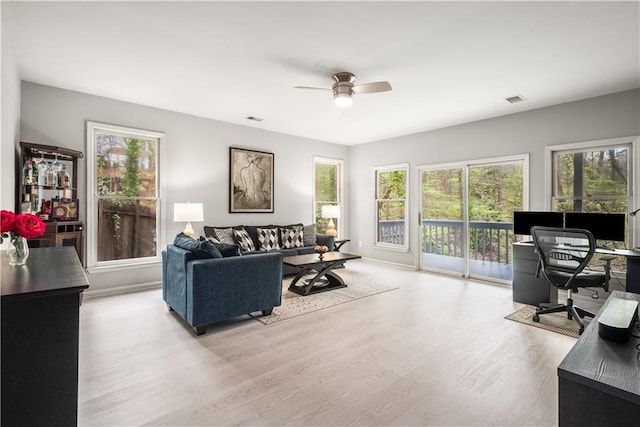 interior space featuring visible vents, baseboards, wood finished floors, and a ceiling fan