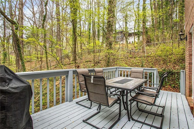 wooden deck featuring area for grilling and outdoor dining area